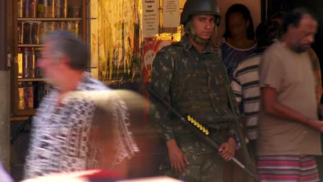 Following-a-couple-walking-in-the-favela-to-reveal-an-armed-military-police-officer