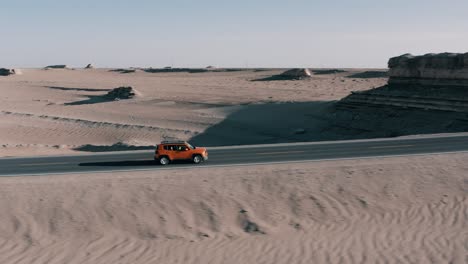 Commercial-ad-of-Jeep-Renegade-Longitude-on-road-in-desert,-aerial-reveal