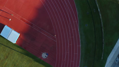 Aerial-4K-Drone-Top-View-Of-Man-Running-Laps-On-Sports-Field-Race-Track,-Australia