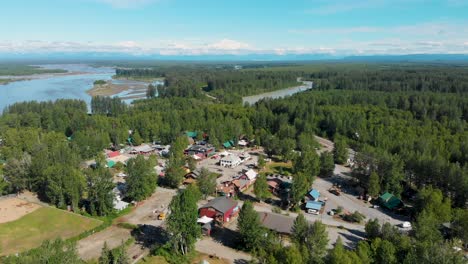4K-Drone-Video-of-Downtown-Talkeetna,-AK-along-the-Susitna-River-with-Denali-Mountain-in-Distance-on-Sunny-Summer-Day