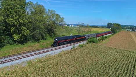 An-Aerial-View-of-an-Antique-Steam-Passenger-Train-Approaching-Blowing-Smoke-and-Steam-Traveling-Thru-Fertile-Corn-Fields-on-a-Sunny-Fall-Day