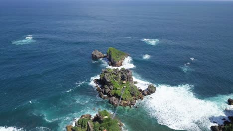 aerial-view-over-a-cliff-on-the-island-of-timang-with-a-view-of-the-coral-islands-in-the-surf-of-the-sea