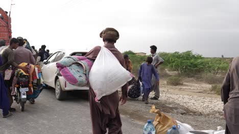 Hombre-Paquistaní-Que-Se-Aleja-Llevando-Un-Paquete-De-Socorro-Por-Inundaciones-En-Baluchistán