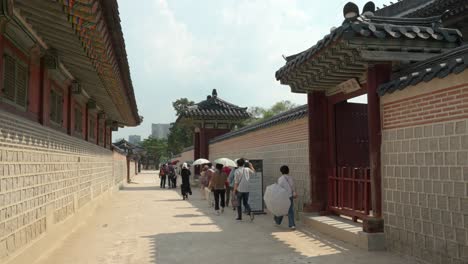 Besucher,-Die-Entlang-Des-Tors-Zum-Gyeonghoeru-pavillon-Im-Gyeongbokgung-palast-In-Südkorea-Gehen