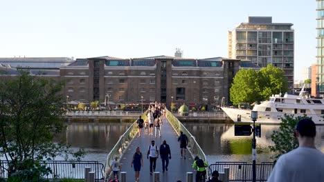London-England-Canary-Wharf-Aug-2022-view-of-West-India-Quay-footbridge-as-people-cross-over-on-a-warm-summer-evening