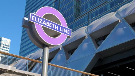 Canary-Wharf,-London,-United-Kingdom---August-2022---A-sign-of-the-new-Elizabeth-Line-in-Canary-Wharf-next-to-Crossrail-Place-Roof-Garden-during-a-sunny-summer-morning