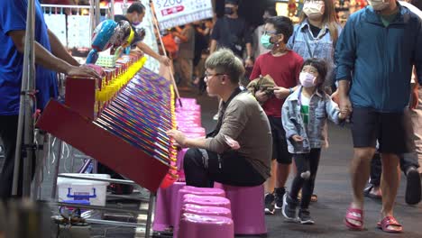 Lokale-Straßenaufnahme-Eines-Männlichen-Erwachsenen,-Der-Spaß-Daran-Hat,-Klassisches-Flipperspiel-Am-Spielstand-Auf-Dem-Berühmten-Nachtmarkt-In-Taiwan,-Asien,-Zu-Spielen