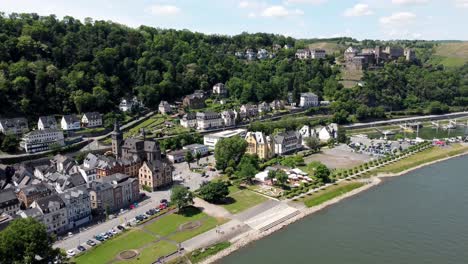 Aerial-flying-drone-shot,-tracking-up,-of-the-Rhine-River-Valley-and-Old-Architecture---including-medieval-castles,-old-buildings,-and-natural-forested-alpine-hills