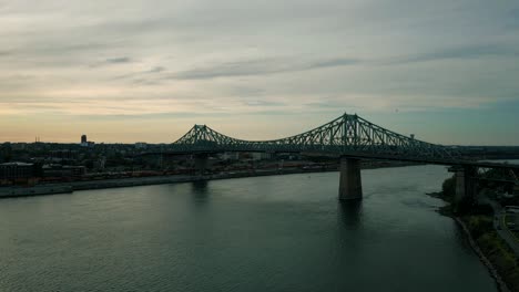 Imágenes-Cinematográficas-De-Drones-Urbanos-De-4k-De-Una-Vista-Aérea-Del-Centro-De-Montreal,-Quebec-Durante-Una-Hermosa-Puesta-De-Sol-Desde-El-Puente-Jacques-Cartier-Sobre-El-Río