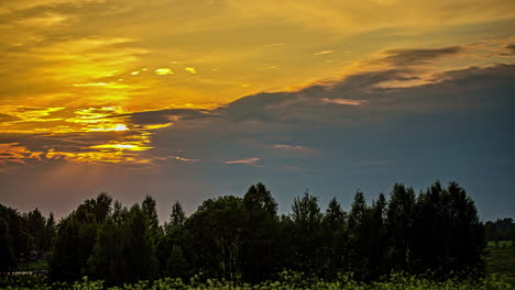 Ein-Goldener-Sonnenuntergang-Und-Eine-Wolkenlandschaft-über-Der-Silhouette-Eines-Waldes---Zeitraffer