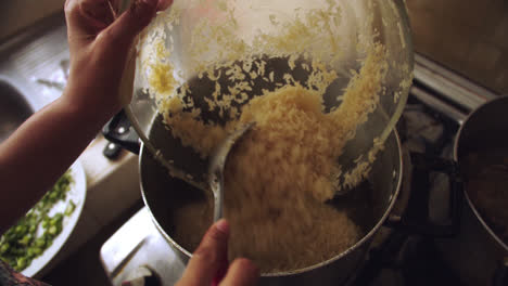 Pouring-raw-rice-with-ladle-into-a-pot-to-be-cooked