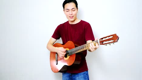 Asiatischer-Kerl,-Der-Fröhliches-Lied-Mit-Seiner-Alten-Akustikgitarre-Spielt