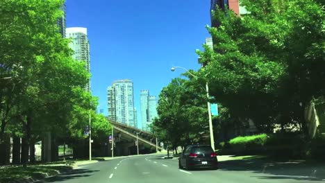 Wide-sunny-shot-looking-forward-through-car-windshield-as-vehicle-clears-intersection-and-travels-east-on-Lakeshore-Avenue-in-Toronto