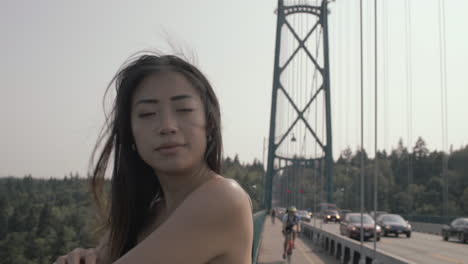 Close-up-portrait-of-very-beautiful-asian-girl-on-Lions-gate-bridge,-Slowmo