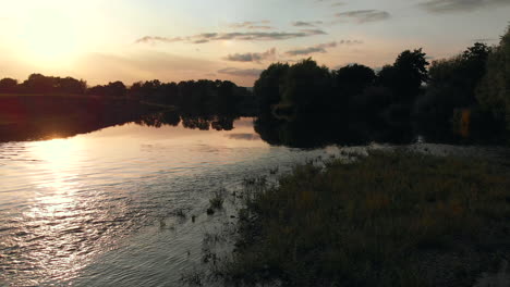 Slow-low-aerial-camera-footage-rising-up-over-the-river-wye-at-sunset-in-summer