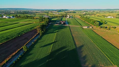 Steam-Train-Passing-through-Amish-Farm-Lands-and-Countryside-on-a-Sunny-Summer-Day-as-seen-by-drone