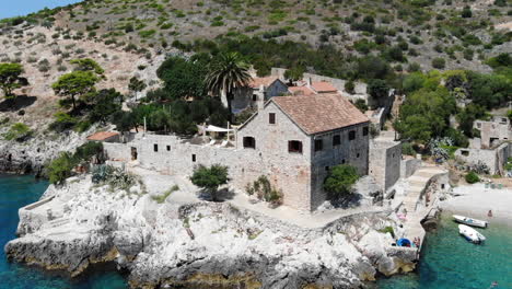 Aerial-drone-shot-of-an-old-stone-villa-on-a-beach-on-the-island-of-Hvar,-Croatia