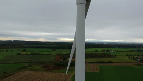 Slow-close-rising-shot-of-wind-turbine-in-British-countryside