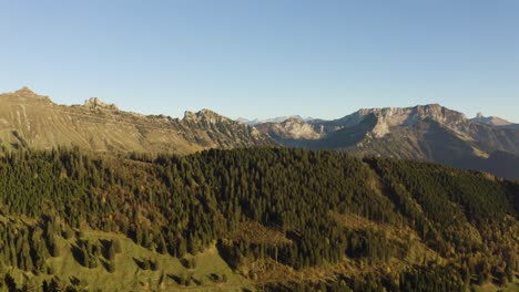 Drone-shot-flying-in-reverse-revealing-Alpine-summits-in-the-background