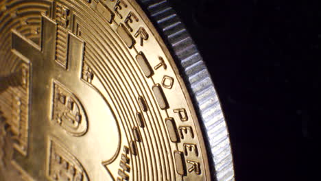 Close-up-reveal-shot-of-a-valuable-gold-shiny-digital-peer-to-peer-cryptocurrency-bitcoin-with-moving-cinematic-lighting