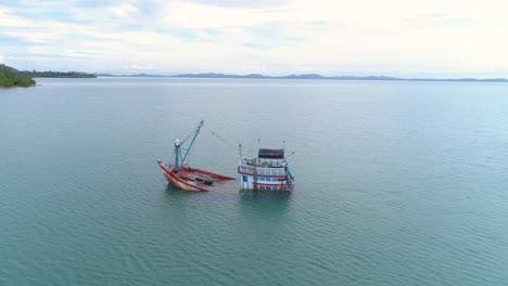 Drone-circling-around-a-sinking-fishing-boat-that-are-being-towed-by-another-boat