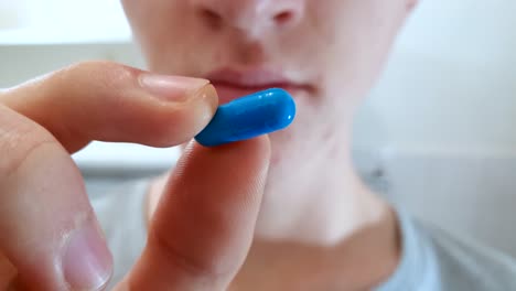 Close-up-of-a-young-teenage-male-nervously-contemplating-taking-a-pill