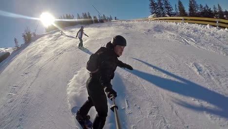 Front-action-cam-view-of-snowboarder-going-down-the-mountain-in-slow-motion-on-a-clear-day