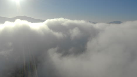 Aerial-view-of-low-fog-over-mountains-in-San-Diego-during-sunrise