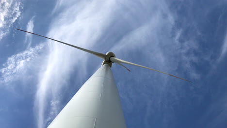Nahaufnahmen-Von-Unten-Einer-Riesigen-Windkraftanlage-Mit-Drei-Rotorblättern-Mit-Himmel-Und-Wolken-Im-Hintergrund,-Die-Saubere-Energie-Erzeugen,-Während-Der-Wind-Weht