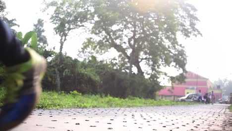 Young-girl-jogging-towards-camera-at-morning-sunrise-or-evening-sunset-on-road,-low-angle-shot