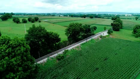 Bahngleise-In-Amischen-Landschaften-Und-Ackerland,-Wie-Von-Drohnen-Gesehen