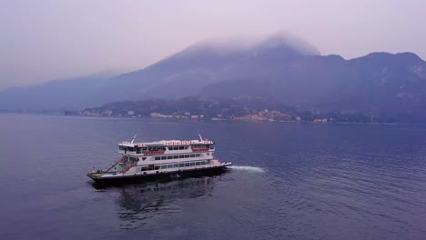 Ferry-Cruzando-El-Lago-De-Como-Saliendo-Del-Puerto-De-Bellagio-Filmado-Desde-El-Aire-En-4k