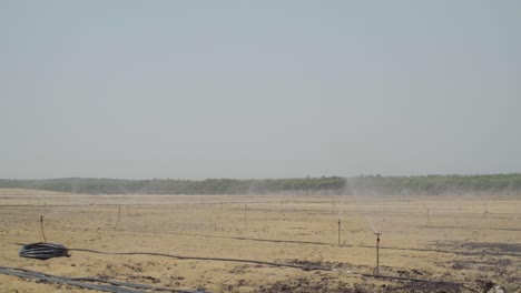 Sprinkler-irrigation-system-watering-farmland-in-Huelva,-Spain,-Wide-Shot