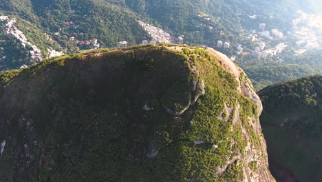 Drohnenaufnahme-Aus-Der-Luft,-Die-Den-Gipfel-Eines-Berges-Umkreist,-Mit-Rio-De-Janeiro-Als-Hintergrund