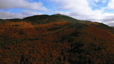 Drone-footage-rising-up-along-the-slope-of-mountain-in-northern-maine-in-peak-autumn-colors