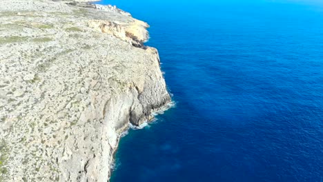 Drone-shot-over-rocks-and-Cliffs-in-the-Mediterranean-sea-of-Malta
