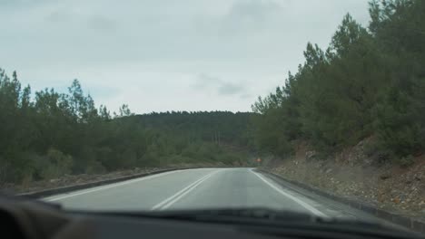road-trip-shot-looking-through-car-window-scenic-forest-route