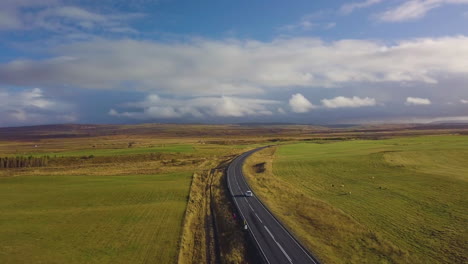 Drone-view-of-cars-driving-down-highway-towards-ominous-cloudy-skies