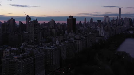 Epischer-Drohnenflug-über-New-Yorks-Central-Park-Onassis-Reservoir-Mit-Großartigem-Blick-Auf-Die-5th-Avenue-Und-Die-Upper-East-Side-Bei-Tagesanbruch,-Sonnenaufgang,-Blauer-Stunde