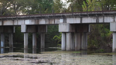 Static-shot-of-an-old-train-bridge-on-the-San-Marcos-River-on-a-long-lens