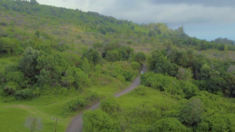 Luftaufnahme-Der-Hawaiianischen-Insel-Maui-Und-Ihrer-Hügeligen-Grünen-Landschaft-Und-Straße