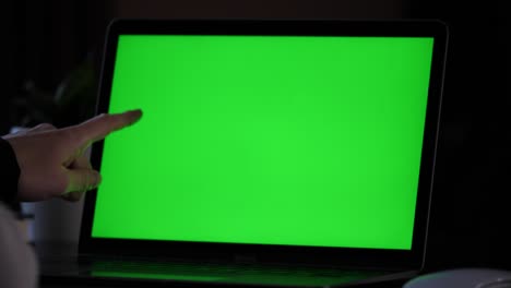 Pointing-with-finger-something-on-green-screen-on-a-laptop,-underlining-a-read-text-with-finger