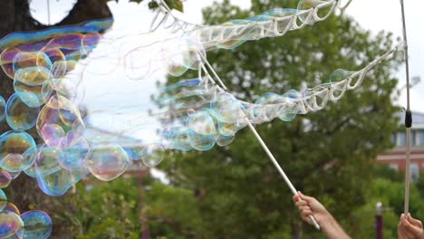Up-Close-Of-Man-Making-Bubbles-In-Public-Park-With-String
