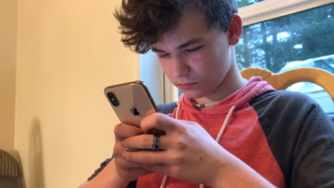 Teenage-boy-texting-madly-on-his-Apple-iPhone-X