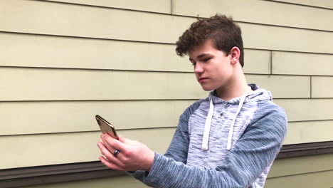 14-year-old-teenage-boy-posing-and-doing-selfies-with-his-iPhone-x