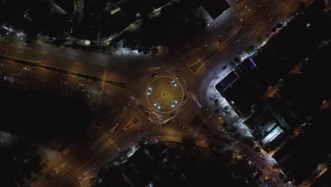 An-aerial-drone-shot-of-Rush-Hour-Traffic-at-Roundabout-Intersection-at-Night---Descending