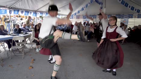 Bailarines-Folclóricos-Alemanes-Actuando-Para-Espectadores-En-Mesas-En-Un-Festival-Octoberfest