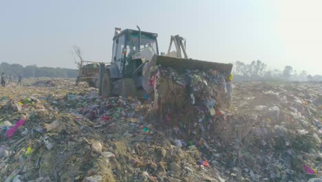 Shot-at-Solid-Waste-Management-Plant,-Haridwar,-Uttarakhand,-India-Garbage-dumping-using-JCB-Machine-at-the-Solid-Waste-Management-Plant
