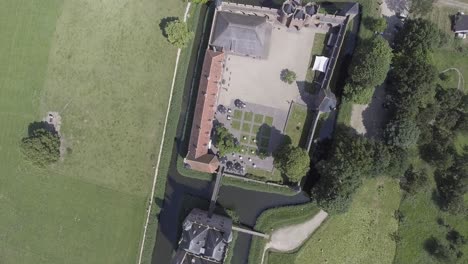 A-drone-shot,-with-the-camera-facing-down-and-moving-forward,-capturing-a-castle-in-The-Netherlands-from-above