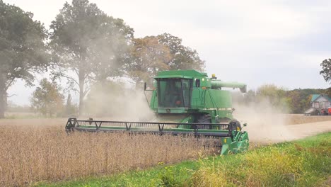 Slow-motion-shot-of-a-combine-harvester-operating-in-a-soybeans-farm